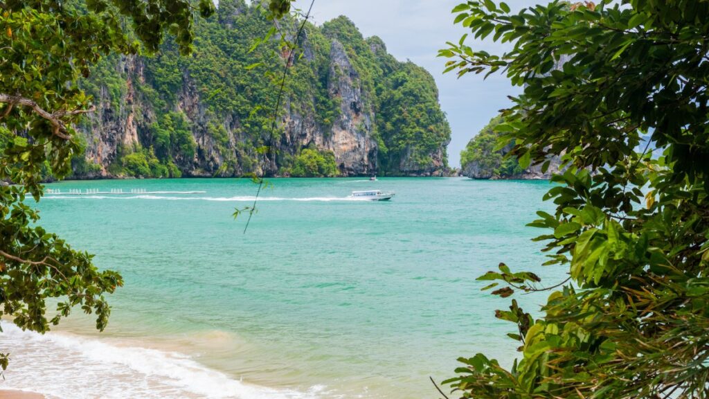 The sea at Pai Plong Beach framed by coastal foliage, Krabi, Thailand